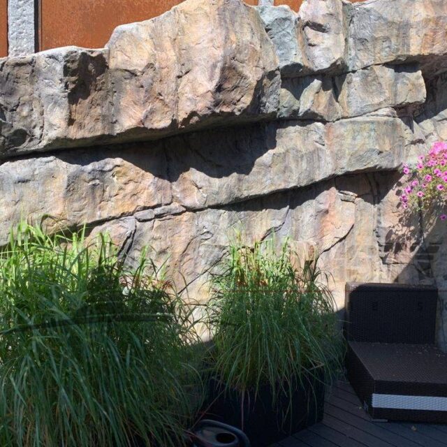 Konstgjorda stenar på en stödmur i trädgården